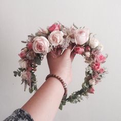 a woman's hand holding a flower wreath