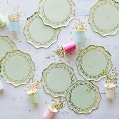 several plates and cups with confetti sprinkles on them