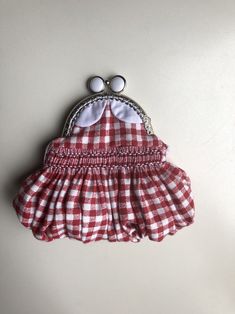 a red and white checkered dress with two eyeballs on the top, sitting on a table