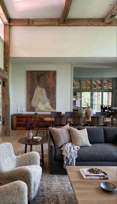 a living room filled with furniture and a large painting on the wall above it's fireplace