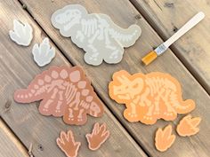 the stencils are being used to make dinosaur stickers on wood planks