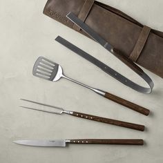 the utensils are laid out on the table next to the bag and knife