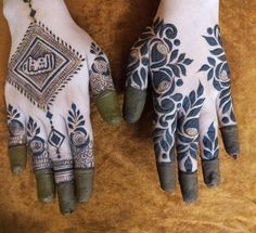 two hands with hendi designs on them, one is green and the other is blue