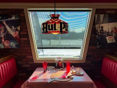 a restaurant with red booth seats and a sign hanging from the ceiling that says hutt pot