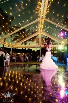 the bride and groom are dancing on the dance floor at their wedding reception in a marquee