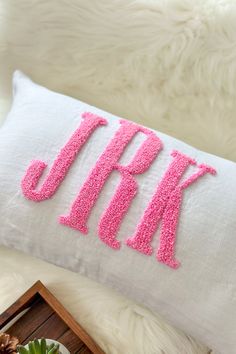 a pillow that has the letters j and k on it with pink sequins