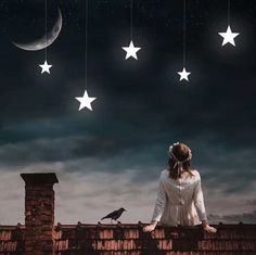 a woman standing on top of a roof next to stars and a bird in the sky