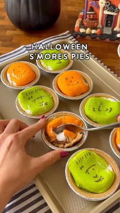 someone is decorating some small pies with green and orange frosting on them