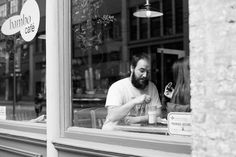 a man sitting at a table in front of a window