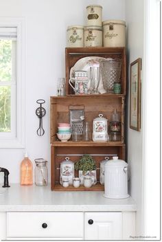 an old wooden shelf filled with dishes and utensils