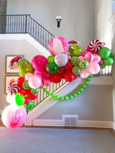 balloon garland on the stair railing with candy canes and lollipops