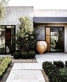 a large vase sitting in the middle of a garden next to a tall planter