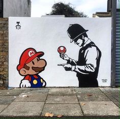 a wall with a painting of a man holding a mushroom next to a cartoon character