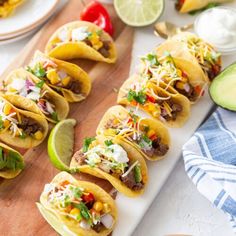 several tacos lined up on a cutting board