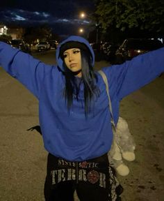 a woman in blue hoodie holding up her arms