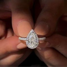 a person holding an engagement ring in their hands