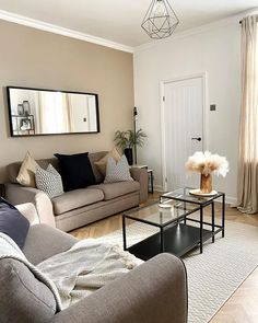 a living room filled with furniture and a mirror on the wall above it's door