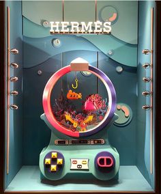 a display case with an arcade machine in the shape of a fish bowl and other items