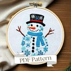 a snowman with a hat and scarf on it's head is shown in the hoop