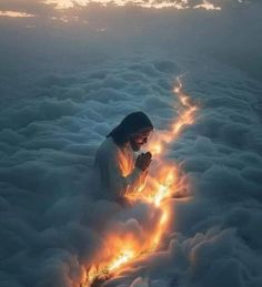 a woman sitting in the clouds with her hands together and lights shining from behind it