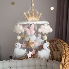 a baby crib mobile with pink, white and gold decorations on top of it