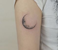 a woman's arm with a half moon tattoo on it