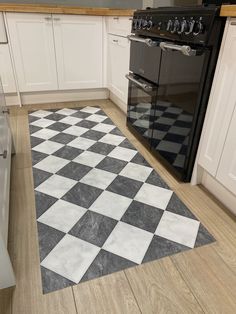 a kitchen with an oven, stove and checkered rug on the floor in front of it