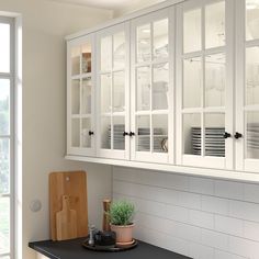 a kitchen with gray cabinets and white counter tops