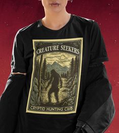 Join the elite ranks of the Creature Seekers in this awesome Cryptid Hunting Club shirt!  Want a different design or color? Just let us know and we'll make it happen!  FIT & SIZING: * These soft and lightweight Bella-Canvas unisex t-shirts have just the right amount of stretch, and are made in the USA. * Tees are comfortable and flattering for both men and women. * Please see the size chart in the photos to obtain an accurate size. Measure one of your favorite tees for comparison! * Ladies: These tees are unisex sizes. Your normal size will fit a bit loosely. For a snug fit, order one size down from your normal size. For an oversized fit, size up.  * Though rolled up in some product pictures, sleeves will not come rolled up on delivery. GARMENT FEATURES: * 100% combed and ring-spun cotton Cryptid Clothes, Cryptidcore Aesthetic Outfits, Cryptid Shirt, Cryptid Hunting, Sasquatch Shirt, Hunting Club, Usa Tee, Hunt Club, Club T Shirt