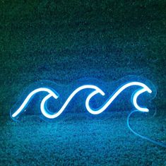 a blue neon sign sitting on top of a grass covered field