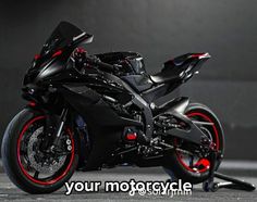 a black motorcycle with red rims parked in a garage