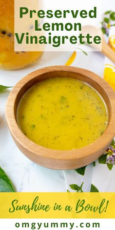 a wooden bowl filled with soup next to a jar of lemon vinaigrette