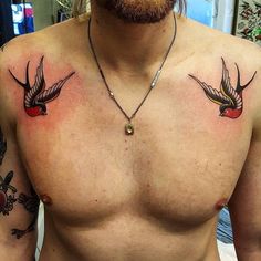 a man's chest with two birds on it and a red apple in the middle