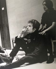 two young men sitting on the floor in front of a mirror talking on their cell phones