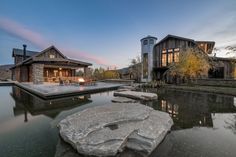 a house with a pool in front of it and a stone patio area next to it