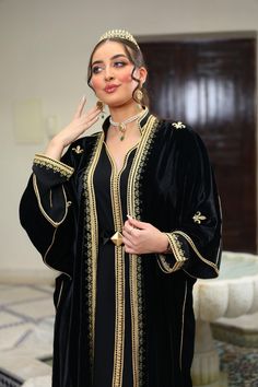 Discover the timeless elegance of this black Moroccan kaftan, a centerpiece for any refined wardrobe. Carefully crafted from high-quality fabric, this kaftan is adorned with delicate gold embroidery that highlights its majestic cut. Ideal for special occasions such as weddings, parties and other festive events, this kaftan combines Moroccan tradition with modern sophistication. Features : - Color: Black with gold embroidery - Material: Velvet (or other fabric depending on the composition) - Deta Luxury Black Traditional Wear With Gold Embroidery, Luxury Gold Embroidered Kaftan, Luxury Black Dress With Gold Embroidery, Luxury Traditional Black Kaftan, Luxury Black Resham Embroidered Kaftan, Luxury Traditional Party Wear With Gold Embroidery, Luxury Traditional Evening Dress For Festive Occasions, Luxury Black Kaftan With Traditional Drape, Luxury Embroidered Black Kaftan