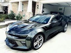 a chevrolet camaro is parked in front of a house