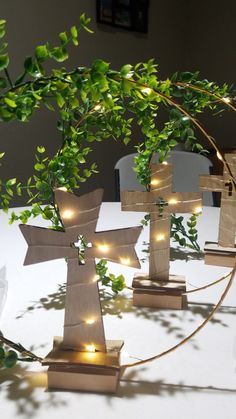 a group of wooden crosses sitting on top of a table next to a tree branch