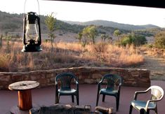 three chairs sitting around a fire pit in the middle of a field