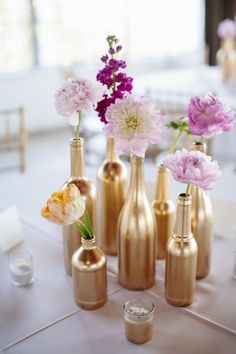 several vases with flowers in them sitting on a table