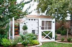 a garden shed with a white door and windows