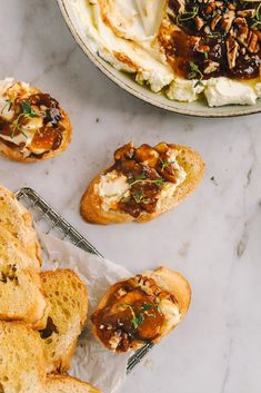 some breads with different toppings on them sitting next to a bowl of ice cream