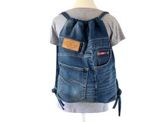 This recycled denim drawstring backpack has a large main compartment with three external pockets. Handmade with 100% recycled denim this backpack is both sustainable and durable. Dimensions: Width 38cm Height 49cm Strap length (x2) 60cm 3x pockets Fully lined *The colour of the denim on your monitor may differ from the original. DISCLAIMER: This is not a licensed Lee Cooper jeans product. It is however, hand-crafted from a pair of preloved Lee Cooper jeans. Denim Travel Backpack, Lee Cooper Jeans, Recycled Denim Bags, Diy Tote, Slouch Bags, Recycle Jeans, Lee Cooper, Upcycle Jeans, Eco Friendly Bags