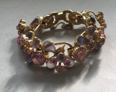 "Delizza and Elster, Juliana design with pink rhinestones and givre lavender satin glass teardrop accents. Beautiful, sparkling diamond like gems on this lovely link bracelet with a gold finish. A larger pink chaton is on a link that links two other ornate gem clusters. A total of five clusters and six large gem connectors. There is a chain guard as well as the very secure clasp. Wear this lovely bracelet on your fanciest outing. Quite a stunning and rare Juliana by Deliza and Elster from their Pink Crystal Bracelet For Formal Occasions, Pink Crystal Bracelets For Formal Occasions, Elegant Pink Jeweled Bracelets, Formal Pink Crystal Bracelet, Elegant Pink Bling Bracelets, Elegant Pink Crystal Bracelet For Formal Events, Jeweled Crystal Bracelet For Wedding, Costume Jewelry Jeweled Crystal Bracelet For Wedding, Costume Jeweled Crystal Bracelet For Wedding