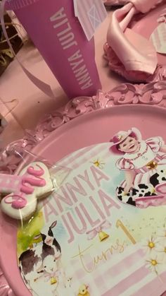 there is a pink plate with an image of a cow on it and some decorations