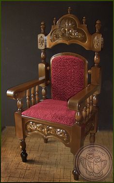 a wooden chair with red upholstered seat and arm rests on a tile floor