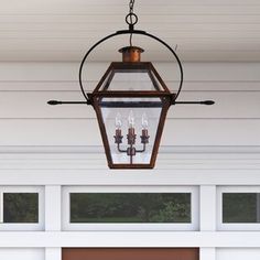 a lantern hanging from the side of a house with three lights on it's sides