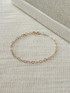 "Hearts are melting for this dainty yet durable mini heart chain bracelet! 💛 This unique chain is sensitive skin and water safe, and is made to live your life in! Wear this minimal piece to brunch, or on a date... this simple heart chain looks lovely anywhere you take it! Details: * 3.5mm 14K Gold Filled heart chain * Dainty 14K Gold Filled spring clasp * 14/20 gf stamp for authenticity * Choose your length (each bracelet comes with a .5\" extender chain for adjustable sizing.) * Made with all Simple Chain Bracelet, Adjustable Dainty Chain Bracelet With Heart Charm, Dainty Bracelets With Adjustable Chain For Valentine's Day, Dainty Adjustable Chain Bracelet For Valentine's Day, Dainty Heart Charm Bracelet For Everyday, Dainty Delicate Chain Bracelets For Valentine's Day, Delicate Heart Bracelet With Chain For Everyday Wear, Delicate Heart Bracelet With Delicate Chain For Everyday, Dainty Everyday Bracelets With Heart Charm