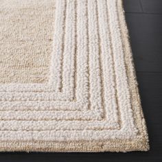 a large white rug on top of a wooden floor