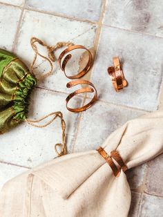 some rings are laying on the floor next to a cloth bag and other items that have been placed around them